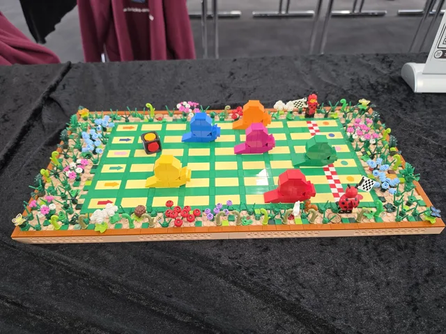 A Mensch-ärgere-dich-nicht board built entirely from LEGO bricks, with a border of flowers